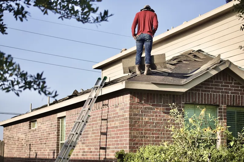 Professional roofer working on a residential roof in Sharpes